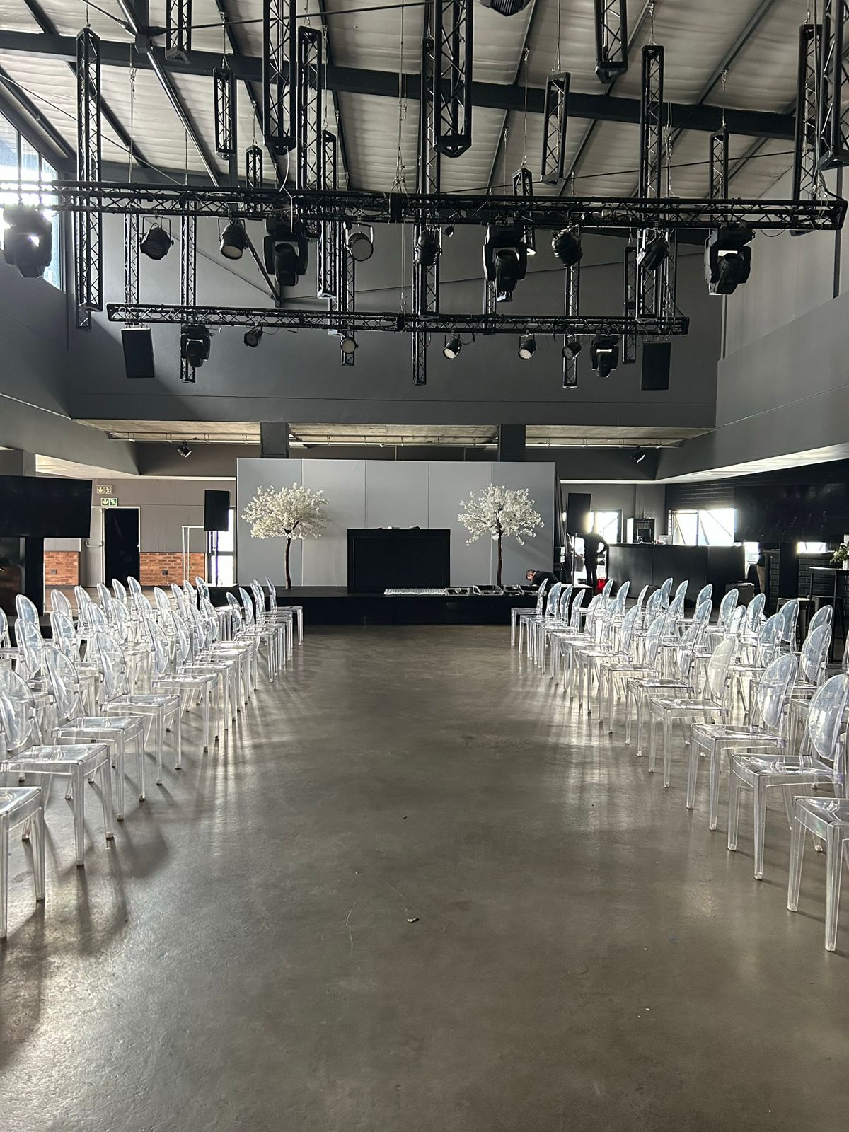 Event hall with ghost chairs and blossom trees